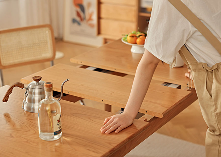 Alma Solid Wood Extendable Table conveniently extends by sliding wood panels outwards, popping up the extra panel in the middle. No latching required.